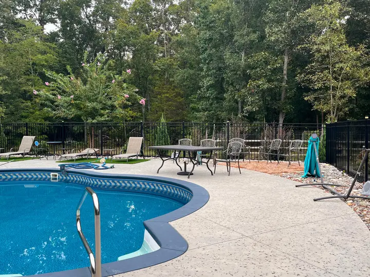 Black aluminum fence surrounding a pool deck