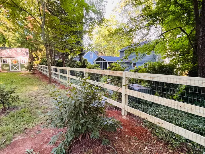 Wood rail and wire fence along a wooded property line