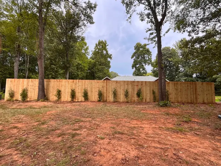 Wood privacy fence in a tree-lined backyard in Huntersville, NC